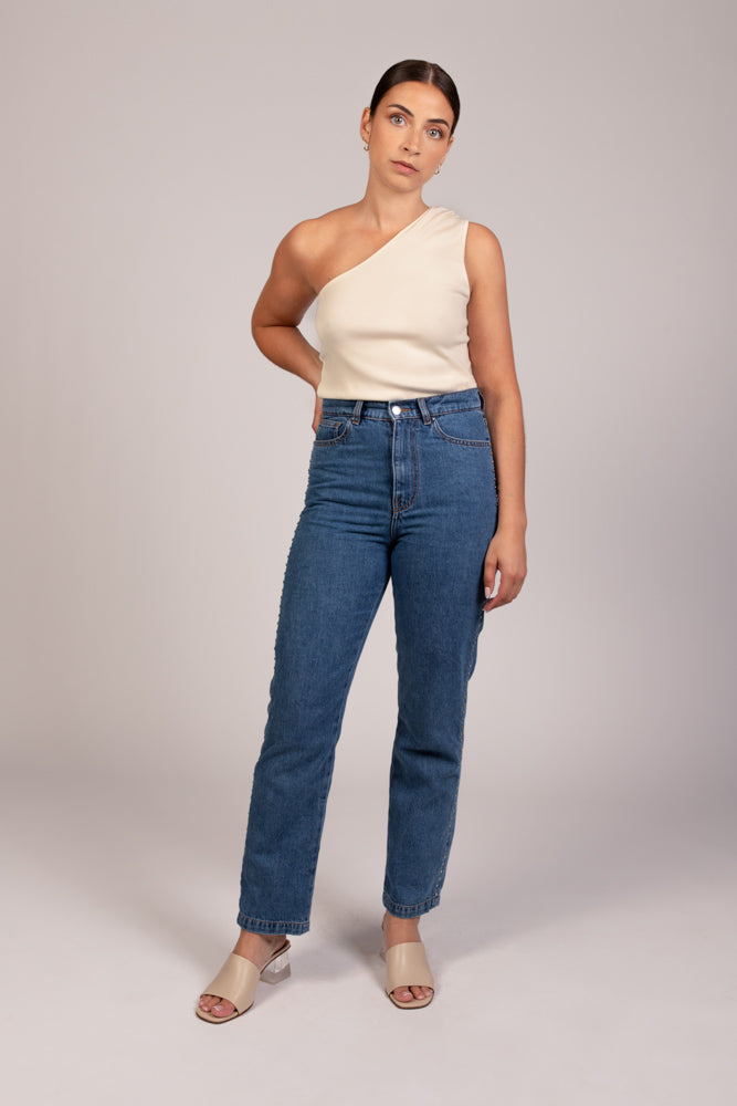 Jean Pat coupe droite avec taille haute, porté avec top NOVA écru asymétrique à une épaule, vue de face. Collection DILAA.