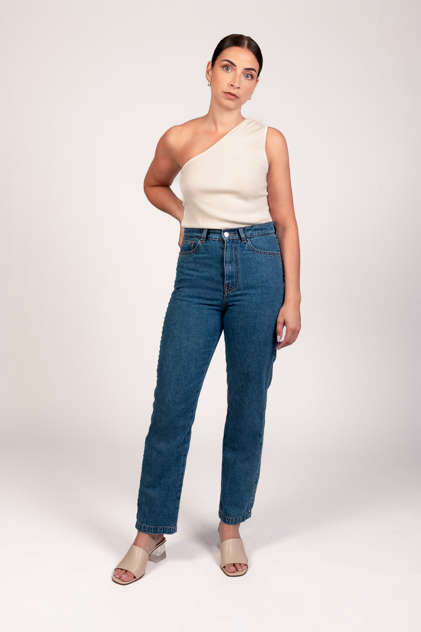 Jean Pat coupe droite avec taille haute, porté avec top NOVA écru asymétrique à une épaule, vue de face. Collection DILAA.