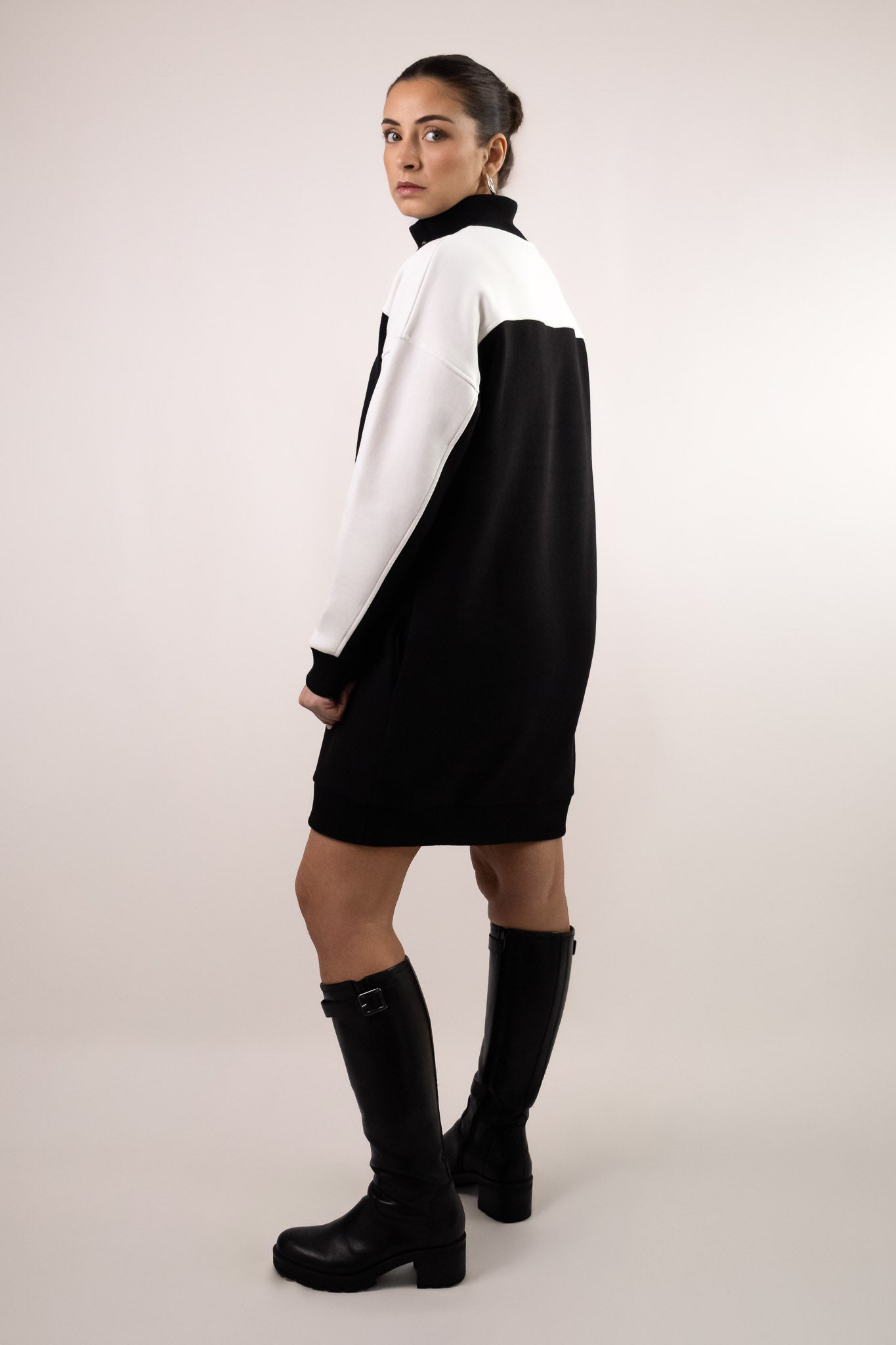 Robe sweat noire et blanc cassé avec col montant à lacage, manches contrastées et coupe droite. Vue en biais. Marque DILAA