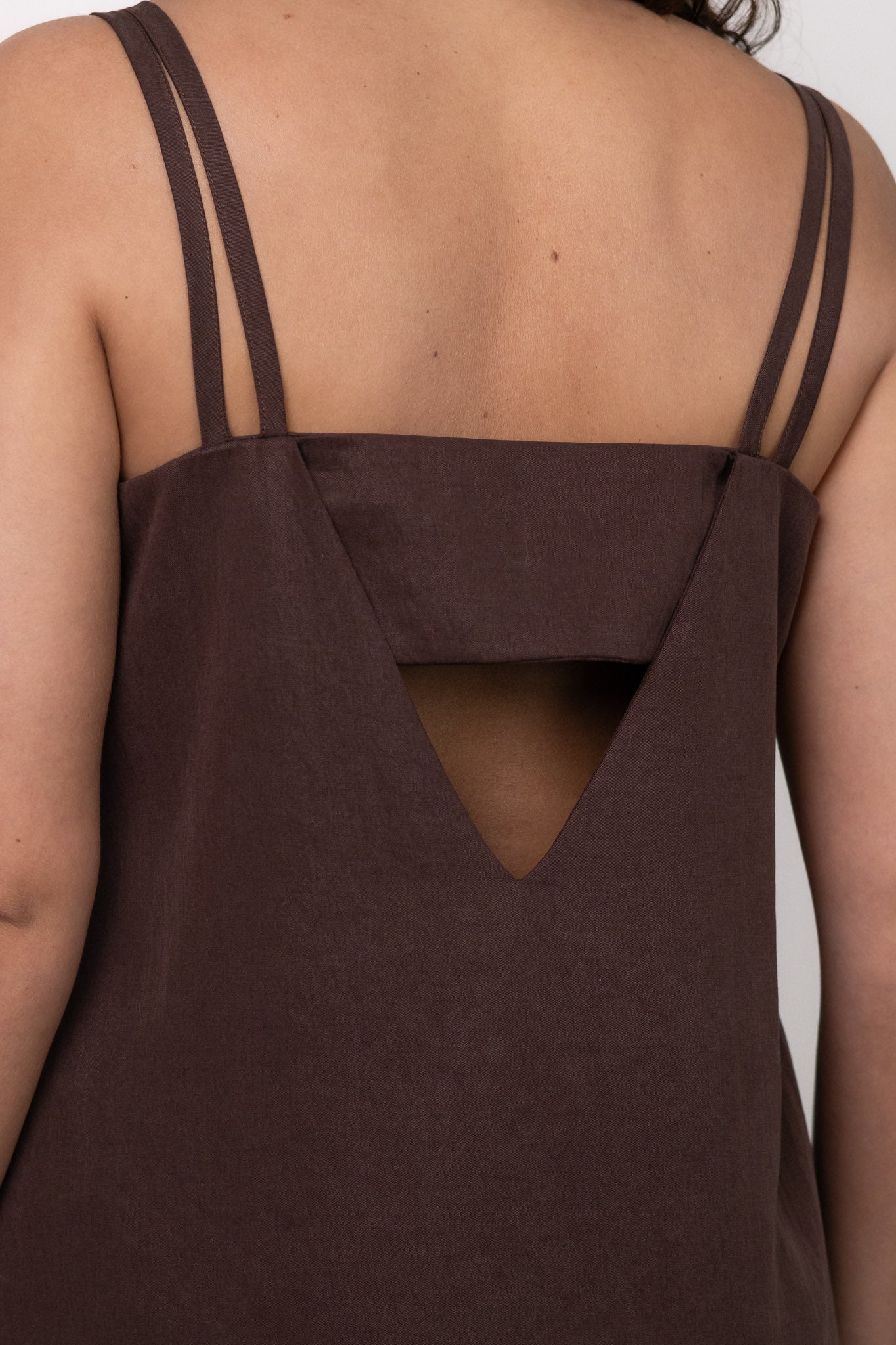 zoom sur le dos de la robe longue fluide marron chocolat DILAA avec dos ouvert et doubles fines bretelles, fabriquée en France.