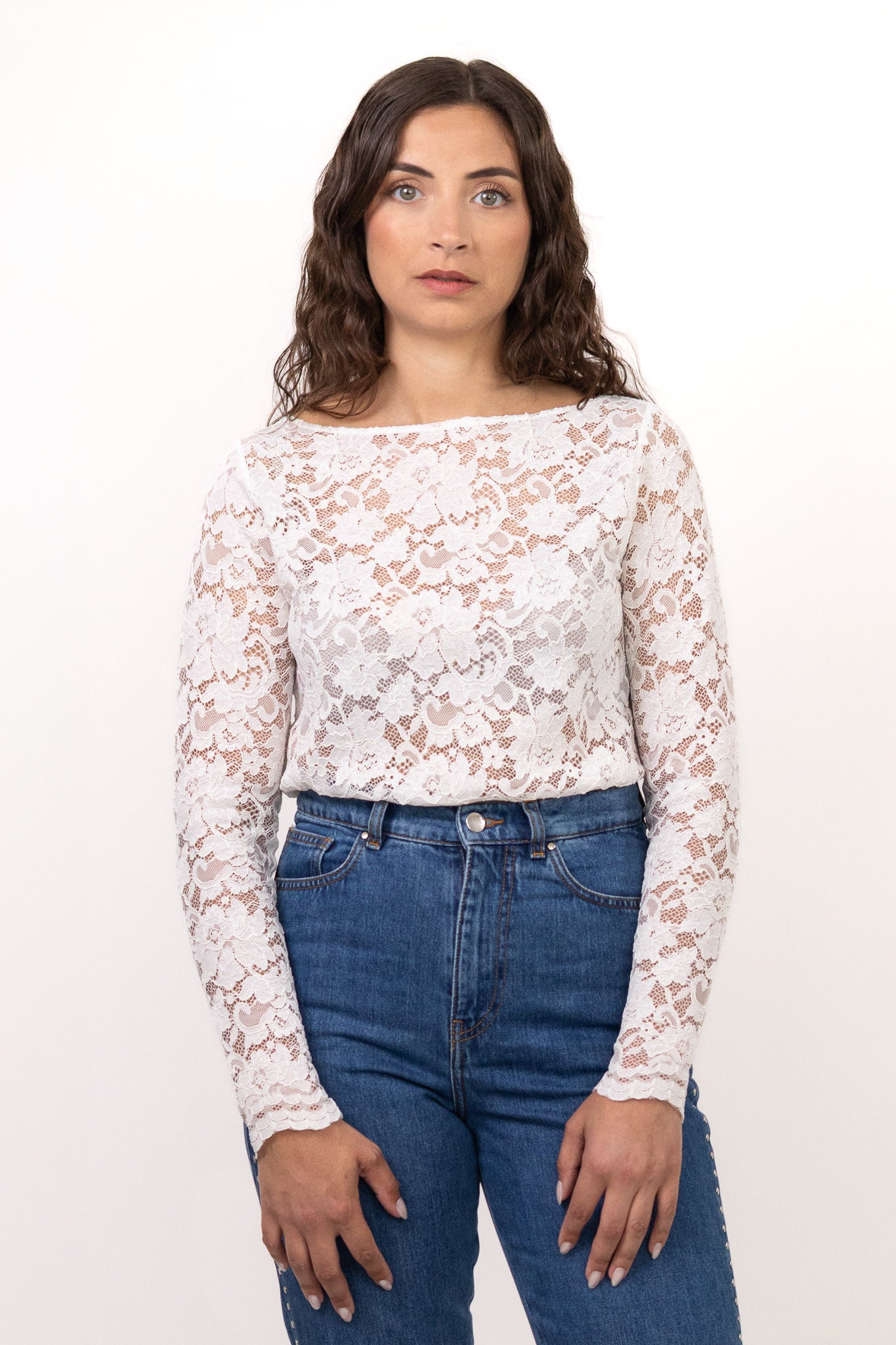Top blanc en dentelle florale DILAA à col bateau et manches longues légèrement transparentes.