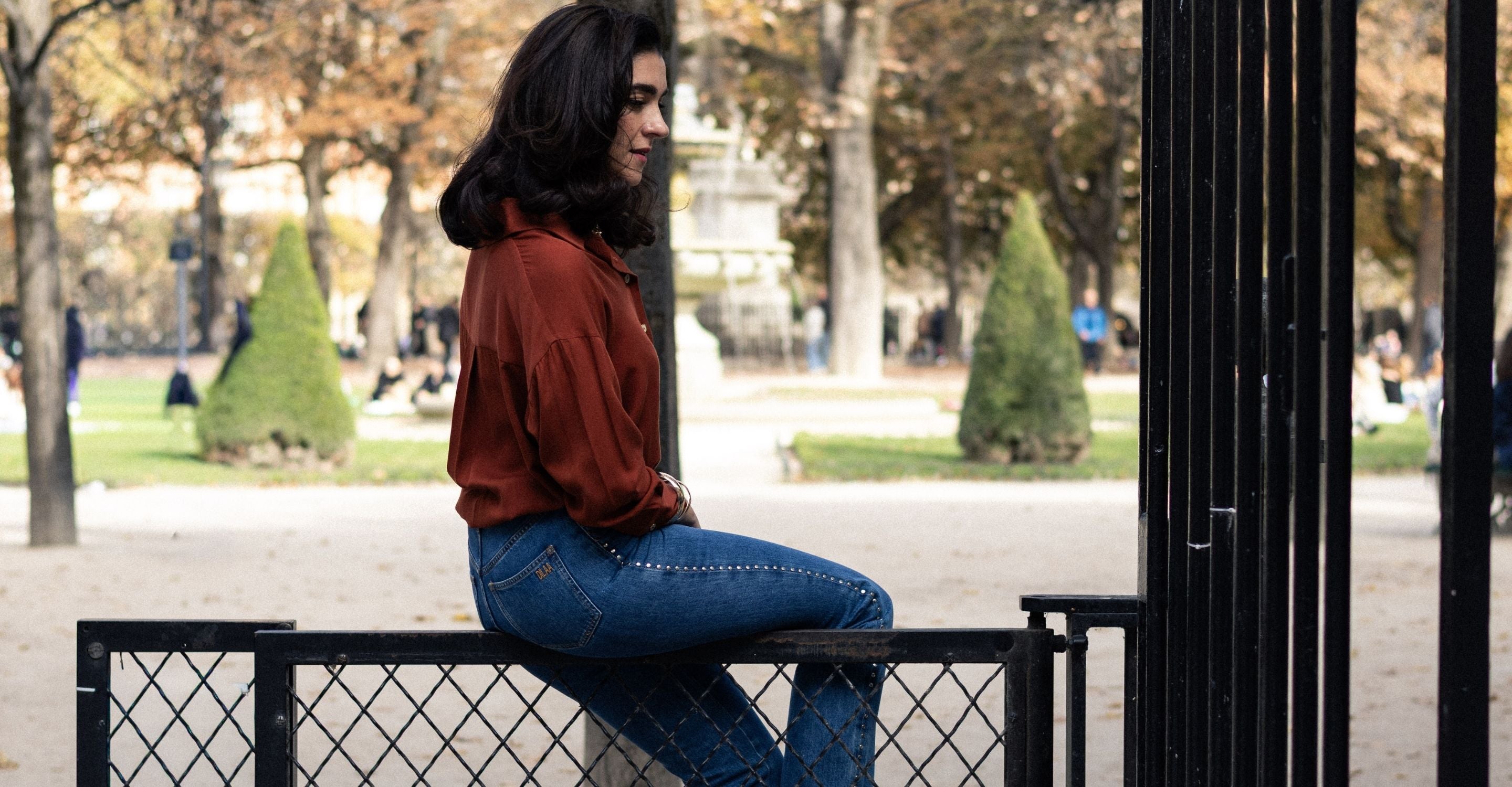 femme assise portant la chemise LIBERTY de la marque DILAA de couleur terracotta avec le jean PAT.