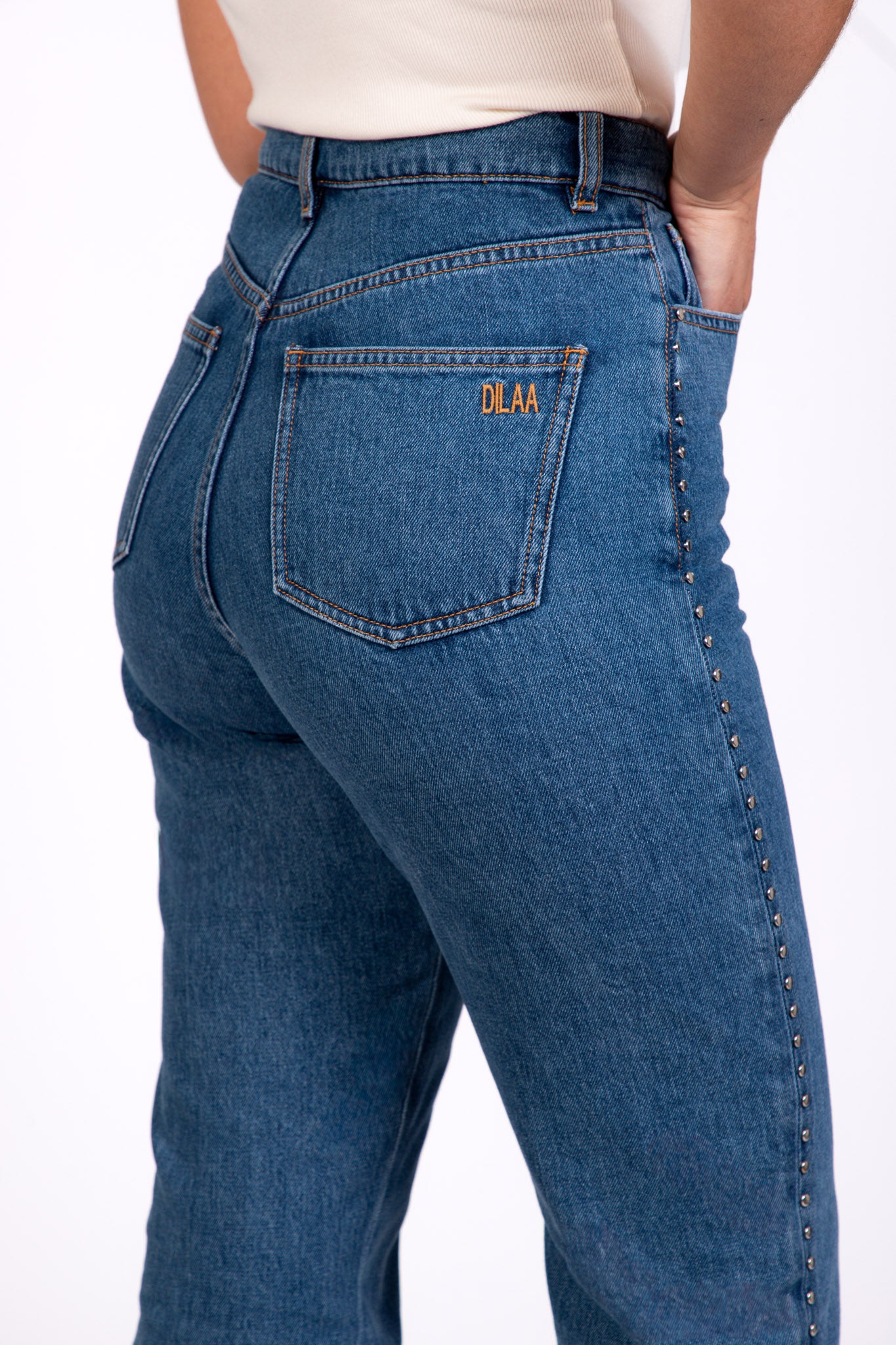 Zoom - Jean Pat coupe droite avec détails cloutés sur les côtés, broderie DILAA sur la poche arrière, vue de dos.