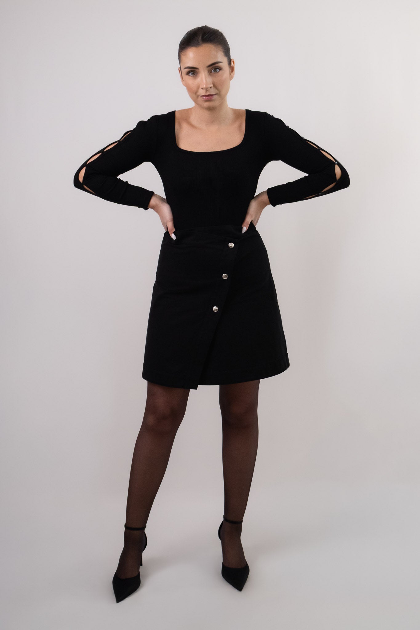 Jupe noire portefeuille MIA portée avec le Top manches longues SOHO. DILAA